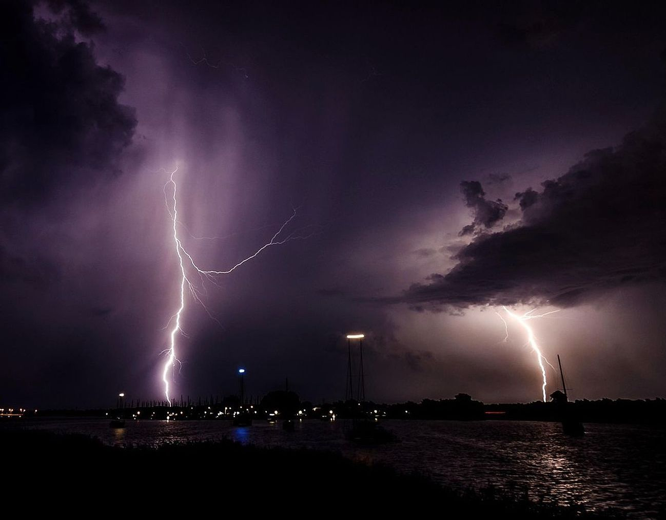 A photographer reviewing storm footage on screen during a thunder-charged evening